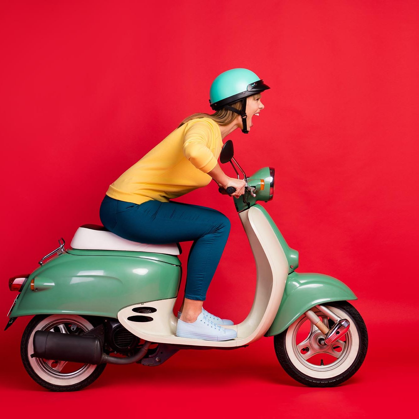 Profile side view portrait of her she nice attractive lovely crazy girlish, cheerful cheery girl riding moped having fun adventure isolated on bright vivid shine vibrant red color background